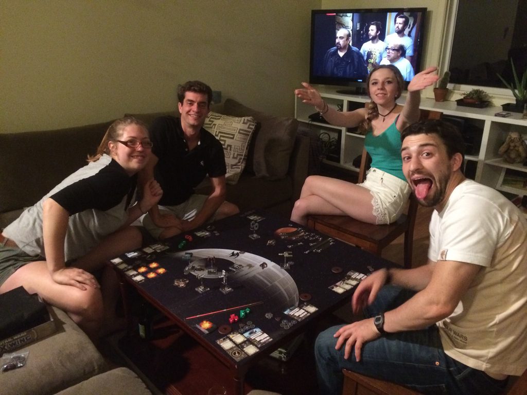 A group of friends plays X-Wing the Miniatures Game.