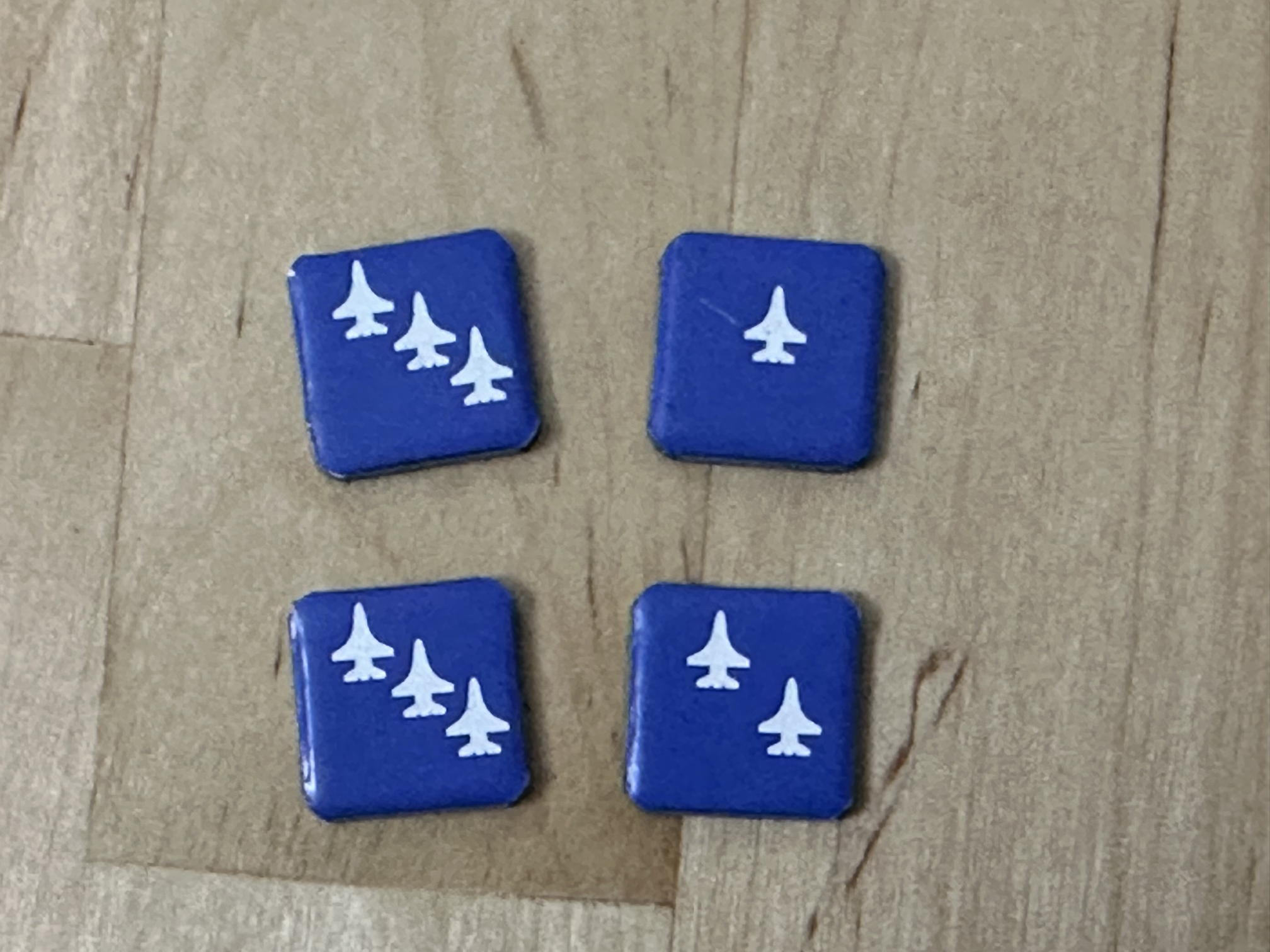 A group of four cardboard counters with rounded corners.