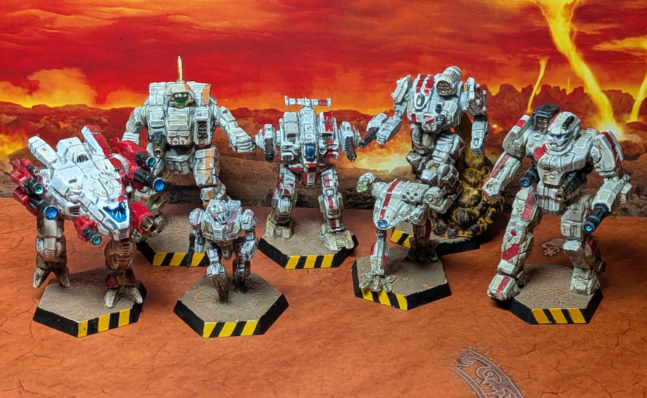 An array of battletech miniatures, painted white with a red stripe. Left to right: Sagittaire, Cyclops, Wasp, Rufleman, Fire Falcon, Thunderbolt and Banshee.