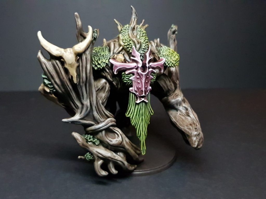 Two-thirds view of a Weaver Courts Crann Guardian, showing the big cow skull stuck to its arm.